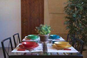einen Tisch mit bunten Schalen und Platten darauf in der Unterkunft Masseria Rosario in Grottaglie