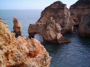 a group of rocks in the water near the ocean at Solar de Mos in Lagos