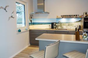 a kitchen with a counter and some chairs in it at Premiumhaus Bodden und Mehr-Brise in Born