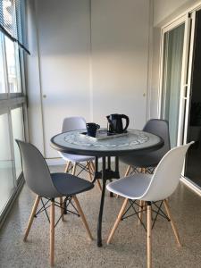 - une table avec quatre chaises et une cafetière dans l'établissement Ruzafa Rincon Español, à Benidorm