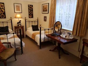 sypialnia z 2 łóżkami, stołem i krzesłem w obiekcie Gothic House w mieście East Grinstead