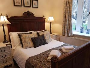 a bedroom with a large bed with pillows and two lamps at Gothic House in East Grinstead