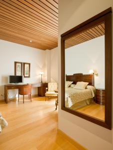 a mirror in a bedroom with a bed and a desk at Bodegas Hacienda Albae in Argamasilla de Alba