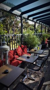 a patio with tables and a couch on a deck at Gothic House in East Grinstead