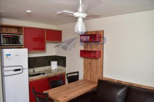 cocina con mesa y ventilador de techo en Casa da Madeira Caldas Novas, en Caldas Novas