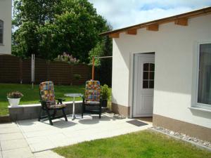 eine Terrasse mit 2 Stühlen und einem Tisch im Hof in der Unterkunft Ferienwohnungen Mülling in Heringsdorf