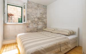 a bed in a bedroom with a stone wall at M.A.S. in Supetar