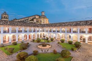 a courtyard with a fountain in front of a building at Hotel Dann Monasterio in Popayan