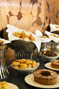 a table topped with bowls of pastries and other foods at Troia Design Hotel in Troia