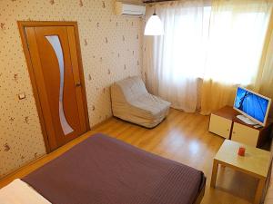 トゥーラにあるInndays on Kirova 151аのベッド、デスク、テレビが備わる小さな客室です。
