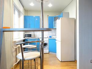 トゥーラにあるInndays on Kirova 151а(2)のキッチン(青いキャビネット、白い冷蔵庫付)