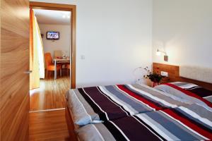 Haus Bergsonne في فلاخاو: غرفة نوم مع سرير وغرفة طعام مع طاولة