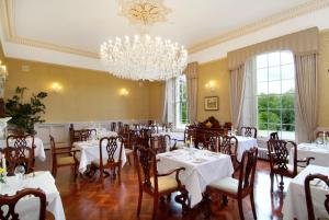 uma sala de jantar com mesas e cadeiras e um lustre em Rockhill House em Letterkenny