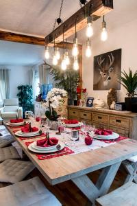 une table en bois avec des assiettes rouges et des verres dans l'établissement Gite Chez Mimie, à Breitenbach-Haut-Rhin