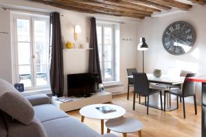 a living room with a couch and a table at Apart By Jo - Proc 2F in Saint-Germain-en-Laye