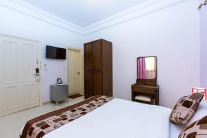 a bedroom with a large bed and a television at Le Feto 3 in Dakar