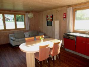 een keuken en een woonkamer met een tafel en een bank bij Naturparadies Silvia in Alberschwende