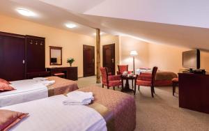 a hotel room with two beds and a flat screen tv at Hotel Adam & Spa in Kudowa-Zdrój