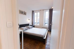 a small bedroom with a bed and a window at Apart By Jo - Proc 2F in Saint-Germain-en-Laye