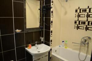 克里沃羅格的住宿－Apartmens on Geroiv ATO，浴室配有水槽、淋浴和浴缸。