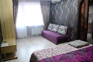 克里沃羅格的住宿－Apartmens on Geroiv ATO，一间卧室配有紫色的沙发和窗户