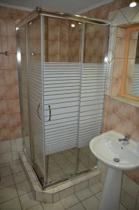 a shower with a glass door next to a sink at Melia Studios in Kato Daratso