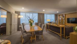 a room with a table and chairs and a television at Clayton Hotel Burlington Road in Dublin