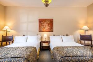 a hotel room with two beds and two lamps at Hotel Dann Monasterio in Popayan