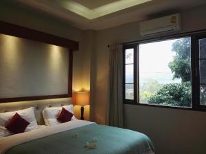 ein Schlafzimmer mit einem Bett und einem großen Fenster in der Unterkunft Green Hill Resort Phurue in Phu Rua