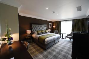 
a hotel room with a large bed and a large window at Ramside Hall Hotel, Golf & Spa in Durham
