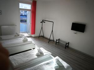 a room with two beds and a flat screen tv at Iceman Room's Central in Bolzano