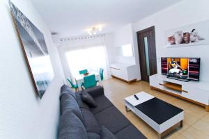 ein Wohnzimmer mit einem Sofa und einem Flachbild-TV in der Unterkunft Playmar in Cambrils
