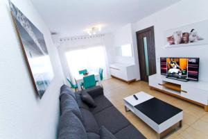 een woonkamer met een bank en een flatscreen-tv bij Playmar in Cambrils