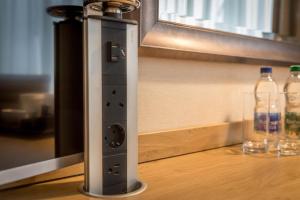 a remote control sitting on a table with two bottles at Clayton Hotel Burlington Road in Dublin
