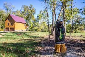 a statue in a yard with a house in the background at Green Castle cabin on the Shenandoah River in Luray