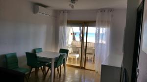 een eetkamer met een tafel en stoelen en uitzicht op de oceaan bij Playmar in Cambrils