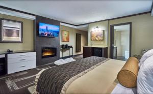 ein Schlafzimmer mit einem großen Bett und einem Kamin in der Unterkunft Best Western Plus Edmonton Airport Hotel in Leduc