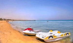 two speed boats on a beach next to the water at Palmera El Sokhna Chalets Families Only in Ain Sokhna