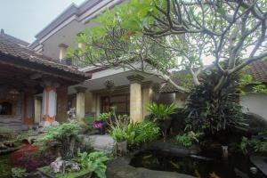 uma casa com um lago de carpas em frente em Jepun Bali Ubud Homestay em Ubud