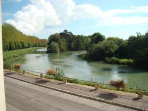 a river next to a road next to a bridge at A la belle dame in Nogent-sur-Seine