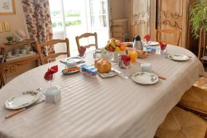 a table with a white table cloth with food on it at Aurore de Beaufort in Saint-Martin-le-Beau