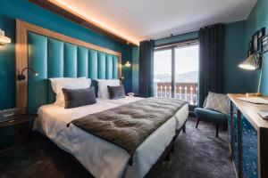 a bedroom with a large bed and a large window at Fahrenheit Seven Courchevel in Courchevel
