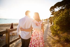 een man en een vrouw die over het strand lopen bij Golfo del Sole Hotel in Follonica