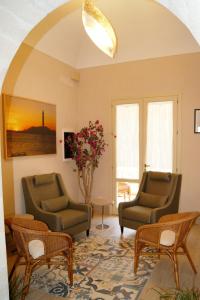 un soggiorno con 2 sedie e un tavolo di Albergo Bouganville a Favignana