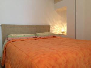 a bedroom with a bed with an orange blanket at Casa Caracciolo B&B in Grottaglie