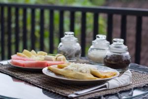 twee borden voedsel op een tafel met fruit en suiker bij Jepun Bali Ubud Homestay in Ubud