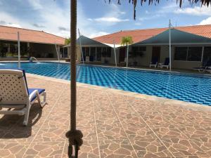 Studio Unit in Beautiful Resort في El Mangote: مسبح مع كرسي بجانب مبنى