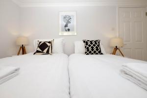 two white beds in a room with two lamps at Central Regency Town House in Brighton & Hove