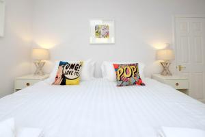 a white bedroom with a white bed with pillows at Central Regency Town House in Brighton & Hove