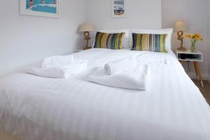 a white bed with towels on top of it at Central Regency Town House in Brighton & Hove